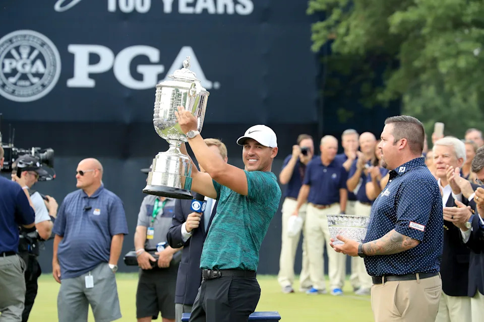 ST LOUIS, MO - AUGUST 12:  Brooks Koepka of the United States raises the Wannamaker Trophy watched by the leading club professional Ben Kern of the United States after his two stroke victory the final round of the 100th PGA Championship at the Bellerive Country Club on August 12, 2018 in St Louis, Missouri.  (Photo by David Cannon/Getty Images)